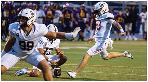 A football player wearing a blue and red jersey. Description generated by AI