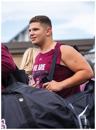 A football player wearing a blue and red jersey. Description generated by AI