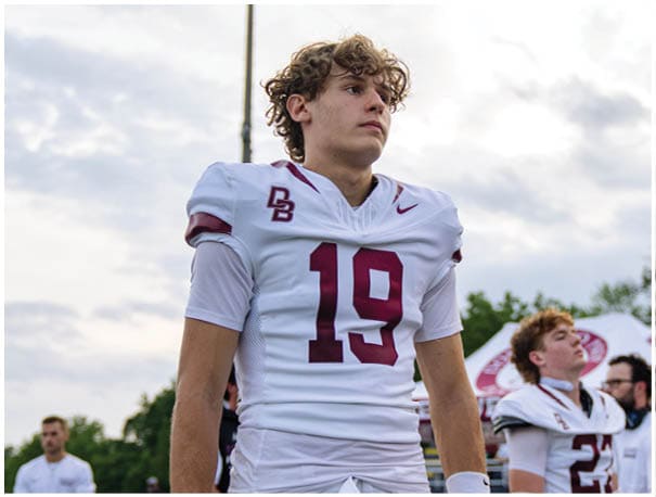 A football player wearing a blue and red jersey. Description generated by AI