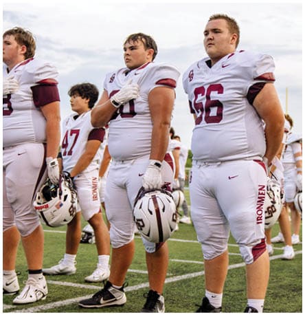 A football player wearing a blue and red jersey. Description generated by AI