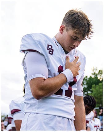 A football player wearing a blue and red jersey. Description generated by AI