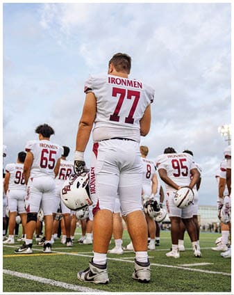 A football player wearing a blue and red jersey. Description generated by AI