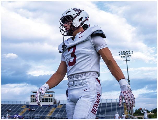 A football player wearing a blue and red jersey. Description generated by AI