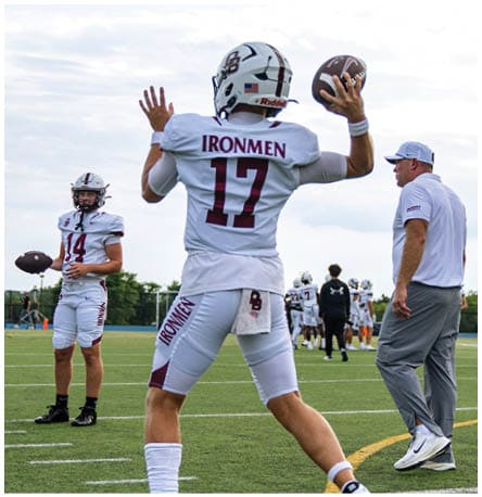 A football player wearing a blue and red jersey. Description generated by AI