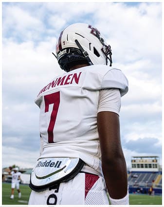 A football player wearing a blue and red jersey. Description generated by AI