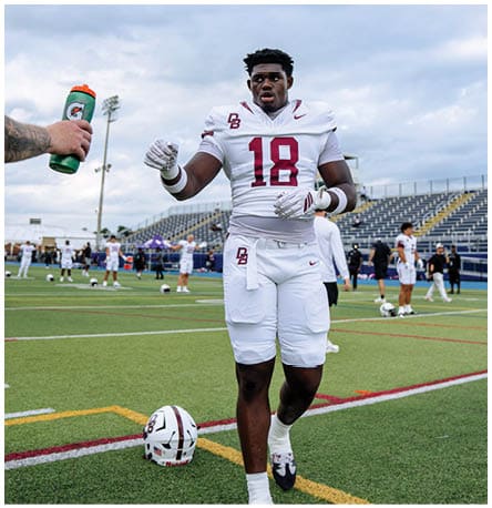A football player wearing a blue and red jersey. Description generated by AI