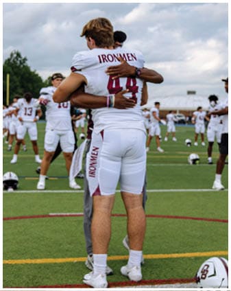 A football player wearing a blue and red jersey. Description generated by AI