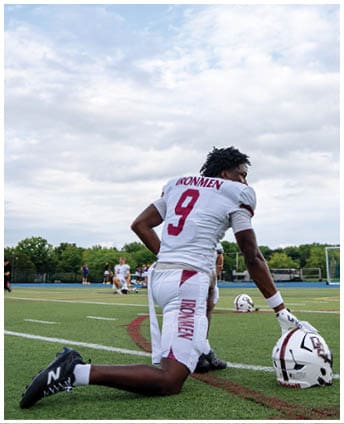 A football player wearing a blue and red jersey. Description generated by AI