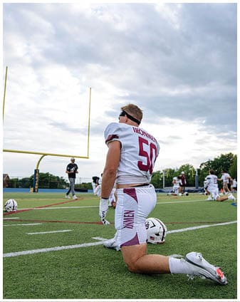 A football player wearing a blue and red jersey. Description generated by AI