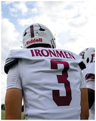 A football player wearing a blue and red jersey. Description generated by AI