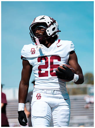 A football player wearing a blue and red jersey. Description generated by AI