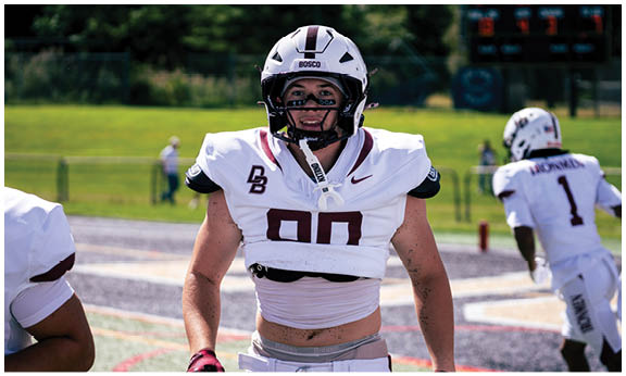A football player wearing a blue and red jersey. Description generated by AI