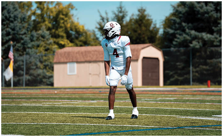 A football player wearing a blue and red jersey. Description generated by AI