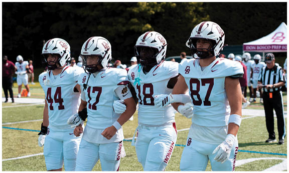 A football player wearing a blue and red jersey. Description generated by AI