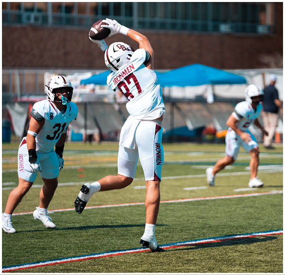 A football player wearing a blue and red jersey. Description generated by AI