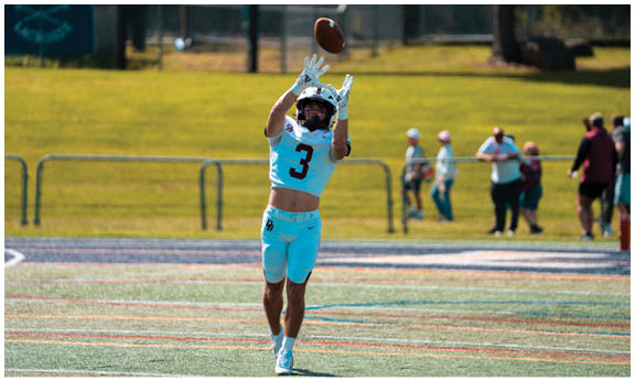 A football player wearing a blue and red jersey. Description generated by AI