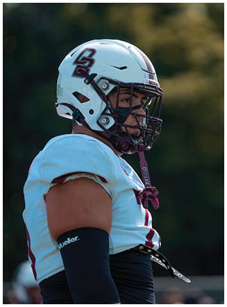 A football player wearing a blue and red jersey. Description generated by AI