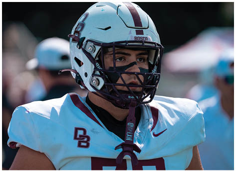 A football player wearing a blue and red jersey. Description generated by AI