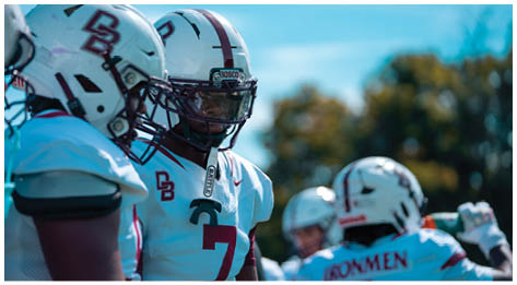 A football player wearing a blue and red jersey. Description generated by AI