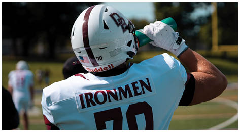 A football player wearing a blue and red jersey. Description generated by AI