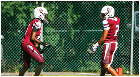 A football player wearing a blue and red jersey. Description generated by AI