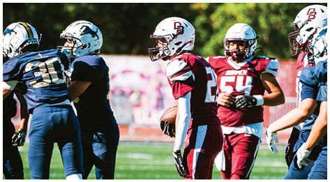 A football player wearing a blue and red jersey. Description generated by AI
