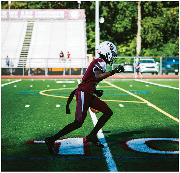 A football player wearing a blue and red jersey. Description generated by AI