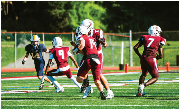 A football player wearing a blue and red jersey. Description generated by AI