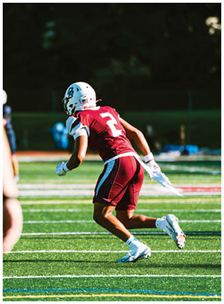 A football player wearing a blue and red jersey. Description generated by AI