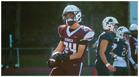 A football player wearing a blue and red jersey. Description generated by AI