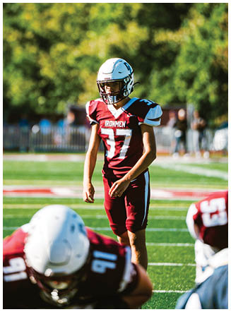 A football player wearing a blue and red jersey. Description generated by AI