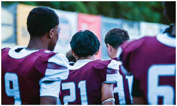 A football player wearing a blue and red jersey. Description generated by AI