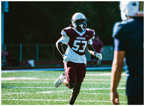 A football player wearing a blue and red jersey. Description generated by AI