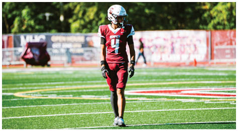 A football player wearing a blue and red jersey. Description generated by AI