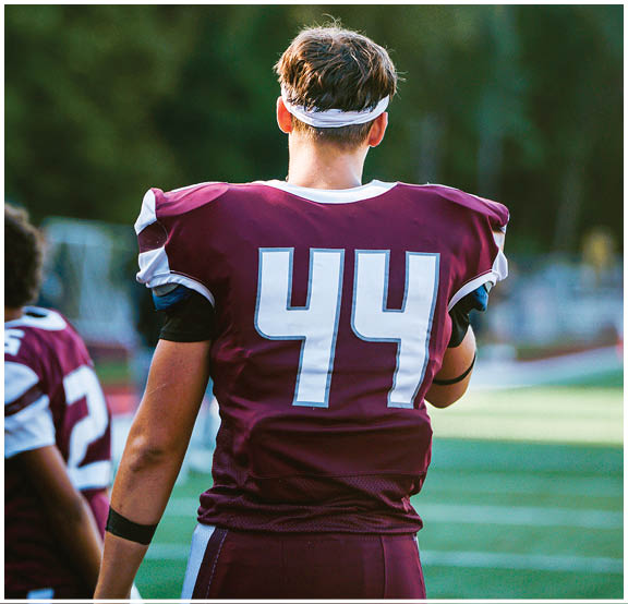 A football player wearing a blue and red jersey. Description generated by AI