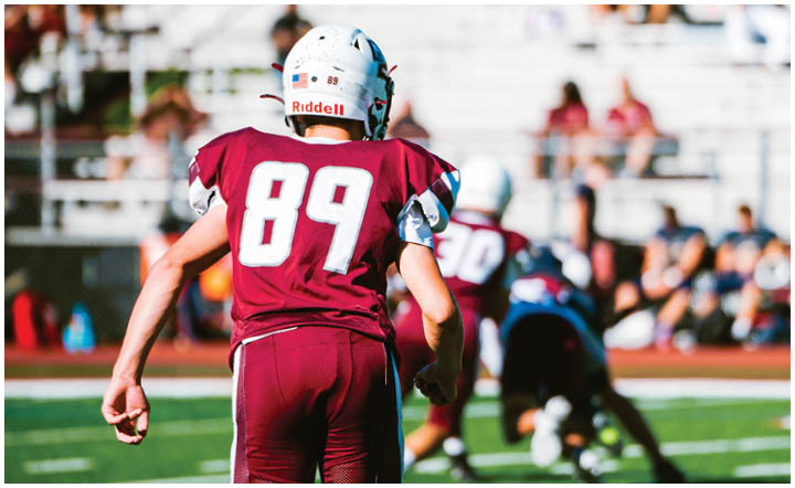 A football player wearing a blue and red jersey. Description generated by AI