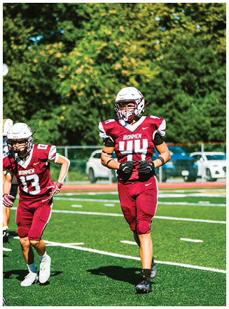A football player wearing a blue and red jersey. Description generated by AI