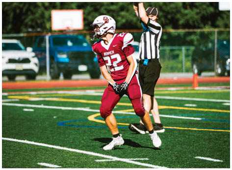 A football player wearing a blue and red jersey. Description generated by AI