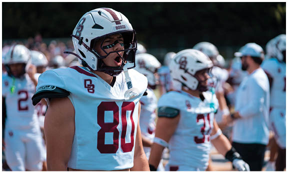 A football player wearing a blue and red jersey. Description generated by AI