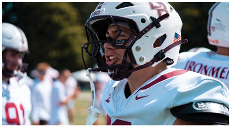 A football player wearing a blue and red jersey. Description generated by AI