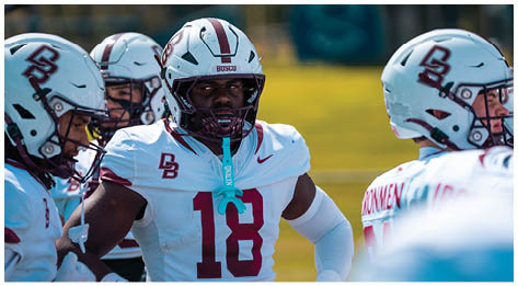 A football player wearing a blue and red jersey. Description generated by AI