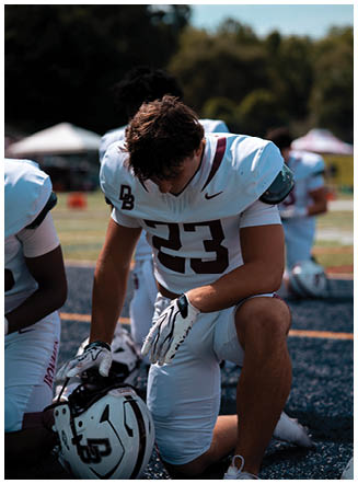A football player wearing a blue and red jersey. Description generated by AI