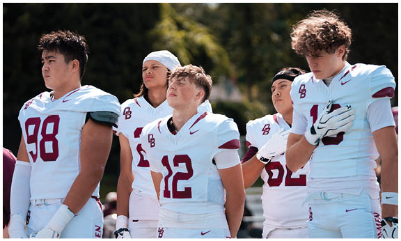 A football player wearing a blue and red jersey. Description generated by AI