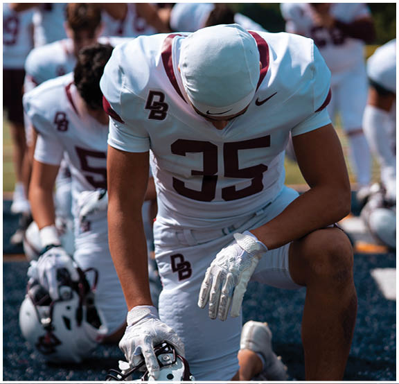 A football player wearing a blue and red jersey. Description generated by AI