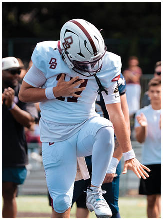 A football player wearing a blue and red jersey. Description generated by AI