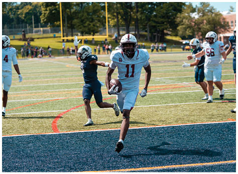 A football player wearing a blue and red jersey. Description generated by AI