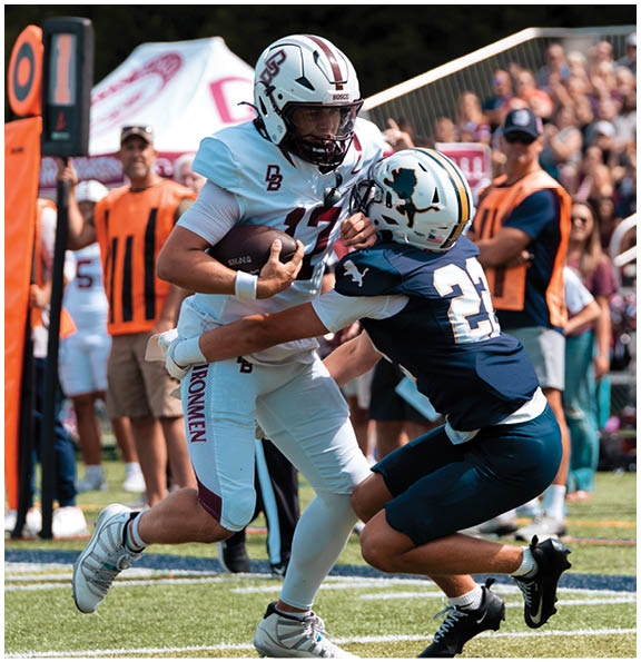 A football player wearing a blue and red jersey. Description generated by AI
