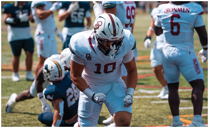 A football player wearing a blue and red jersey. Description generated by AI