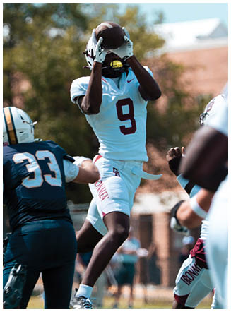 A football player wearing a blue and red jersey. Description generated by AI
