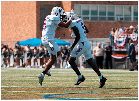 A football player wearing a blue and red jersey. Description generated by AI